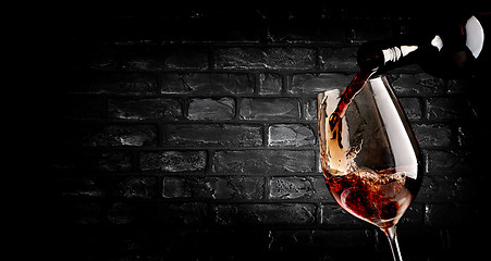 Image showing Pouring wine and brick wall