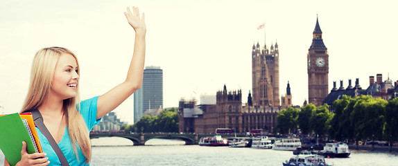 Image showing student with folders waving hand over london city