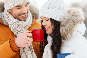 Image showing happy couple with tea cups over winter landscape