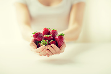 Image showing close up of woman hands holding strawberries