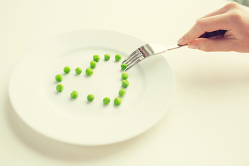 Image showing close up of woman with fork eating peas