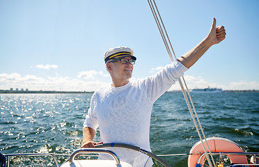 Image showing senior man at helm on boat or yacht sailing in sea