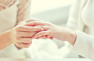 Image showing close up of lesbian couple hands with wedding ring