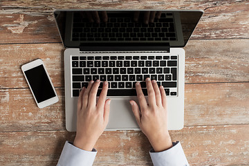 Image showing close up of hands with laptop and smartphone