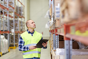 Image showing man with clipboard in safety vest at warehouse