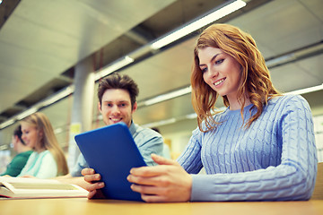 Image showing happy students with tablet pc in library