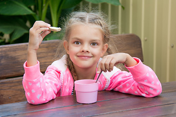 Image showing Six-year girl has breakfast on the veranda