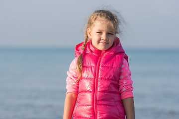 Image showing Portrait of the girl in a jacket in the early morning on the beach