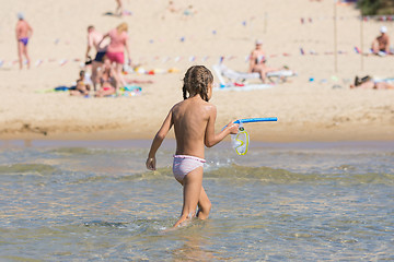 Image showing girl out of the water while holding the mask and a swimming tube in his hands