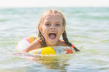 Image showing Six year old girl bathing in the sea with his mouth open in pleasure