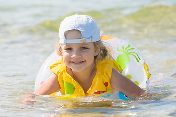 Image showing Four-year girl swims in the summer with a circle in the sea