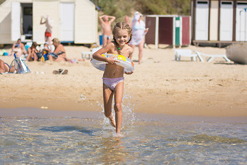 Image showing Happy girl running to swim in the sea