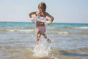 Image showing Girl runs to bathe in the sea, focus on a spray of water