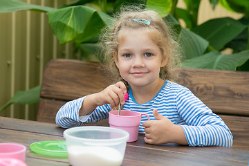 Image showing The four-year girl in tea interferes with sugar for breakfast