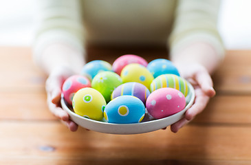 Image showing close up of woman hands with colored easter eggs