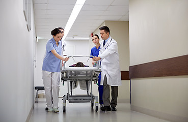 Image showing medics and patient on hospital gurney at emergency