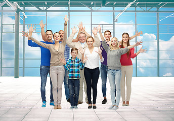 Image showing group of smiling people waving hands