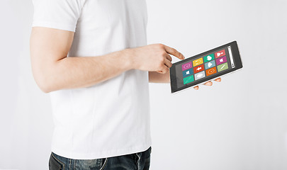 Image showing close up of man with app icons on tablet pc
