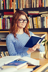 Image showing happy student girl reading book in library