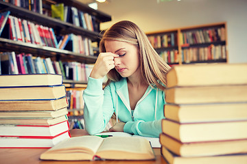 Image showing bored student or young woman with books in library