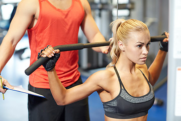 Image showing man and woman flexing muscles on gym machine