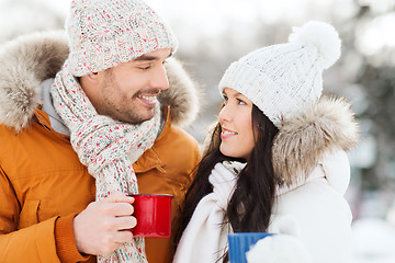 Image showing happy couple with tea cups over winter landscape