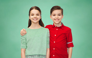 Image showing happy boy and girl hugging over green chalk board