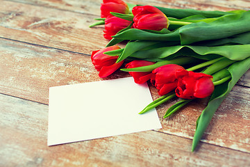 Image showing close up of red tulips and blank paper or letter