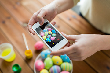 Image showing close up of hands with easter eggs and smartphone