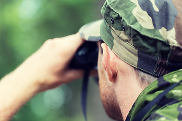 Image showing close up of soldier or hunter with binocular