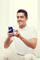 Image showing happy man with smartphone at home