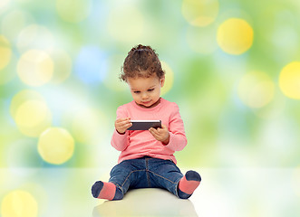 Image showing smiling little baby girl playing with smartphone