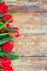 Image showing close up of red tulips on wooden background