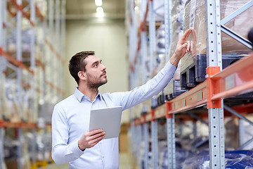 Image showing businessman with tablet pc at warehouse