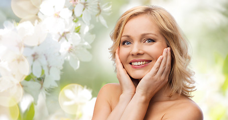 Image showing smiling woman with bare shoulders touching face