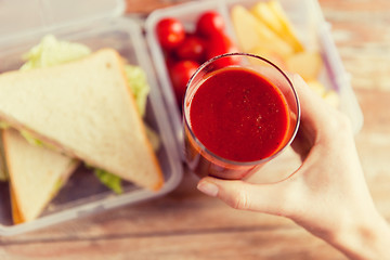 Image showing close up of woman hand holding tomato juice glass