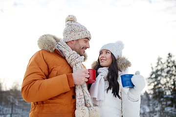 Image showing happy couple with tea cups over winter landscape