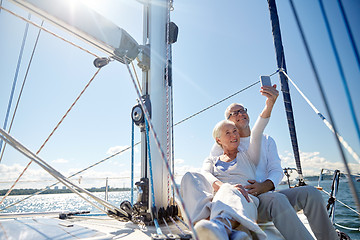 Image showing seniors with smartphone taking selfie on yacht