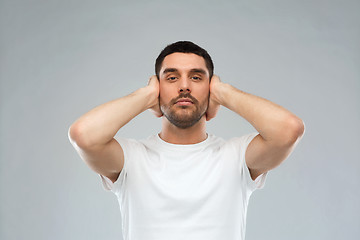 Image showing latin man covering his ears with hand palms