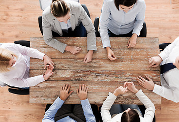 Image showing close up of business team sitting at table