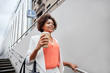 Image showing happy african businesswoman with coffee in city