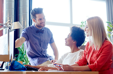 Image showing happy creative team with computer in office