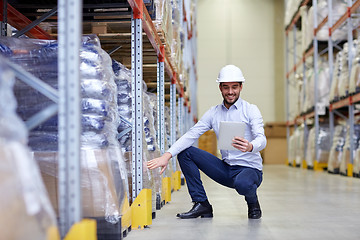 Image showing happy businessman with tablet pc at warehouse