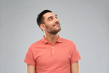 Image showing smiling man looking up over gray background