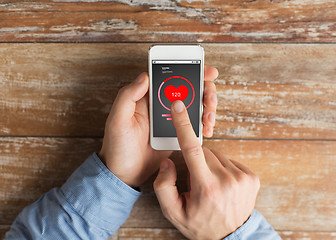 Image showing close up of male hands with smartphone on table