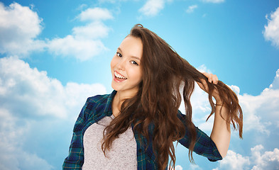 Image showing happy teenage girl holding strand of her hair