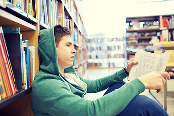 Image showing student boy or young man reading book in library