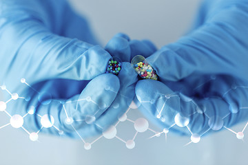 Image showing close up of scientist hands holding pill in lab