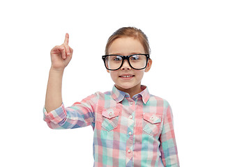 Image showing happy little girl in eyeglasses pointing finger up