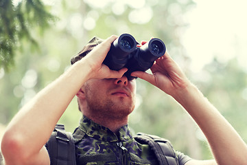 Image showing young soldier or hunter with binocular in forest